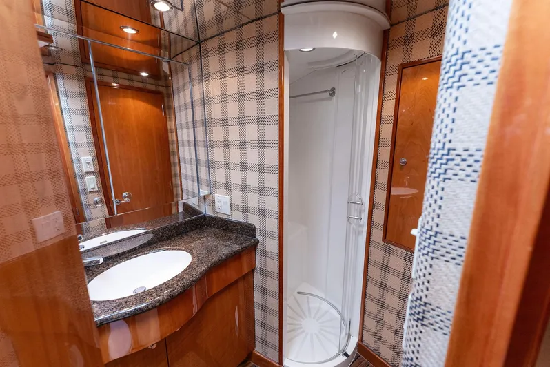 Chupacabra Yacht Photos Pics 2007 Hatteras 64 Convertible yacht bathroom with shower, sink, and wood accents.