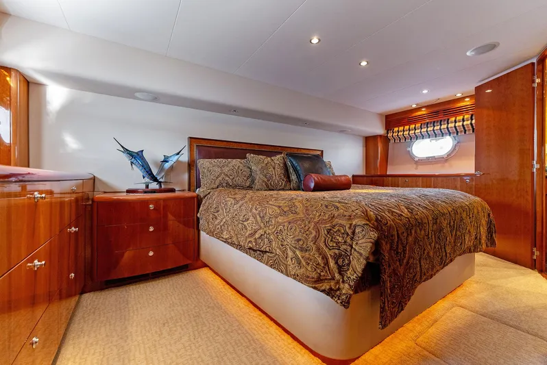 Chupacabra Yacht Photos Pics Luxurious bedroom interior of 2007 Hatteras 64 Convertible yacht with elegant wood finishes.