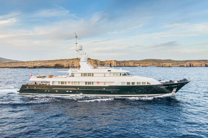 Emerald Yacht Photos Pics Luxurious 1990 Feadship yacht cruising on open sea under a clear sky.