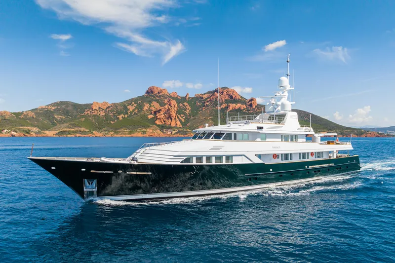 Emerald Yacht Photos Pics Luxurious 1990 Feadship yacht cruising in scenic coastal waters.