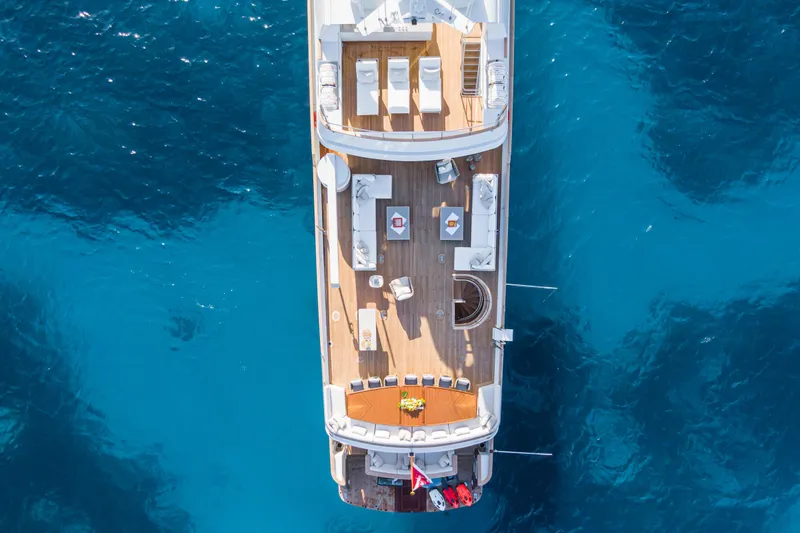 Emerald Yacht Photos Pics Aerial view of 1990 Feadship yacht on clear blue water.
