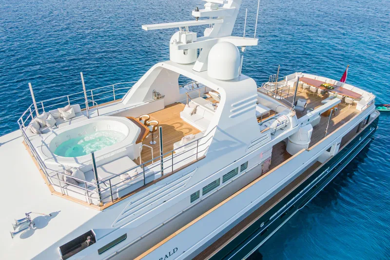 Emerald Yacht Photos Pics Luxurious 1990 Feadship yacht with jacuzzi, spacious deck, and elegant design on blue ocean waters.