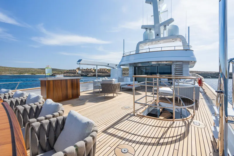 Emerald Yacht Photos Pics Luxurious 1990 Feadship yacht deck with elegant seating and ocean view.