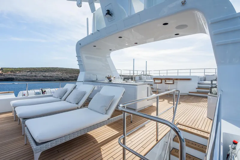 Emerald Yacht Photos Pics Luxurious 1990 Feadship yacht deck with sun loungers and ocean view.