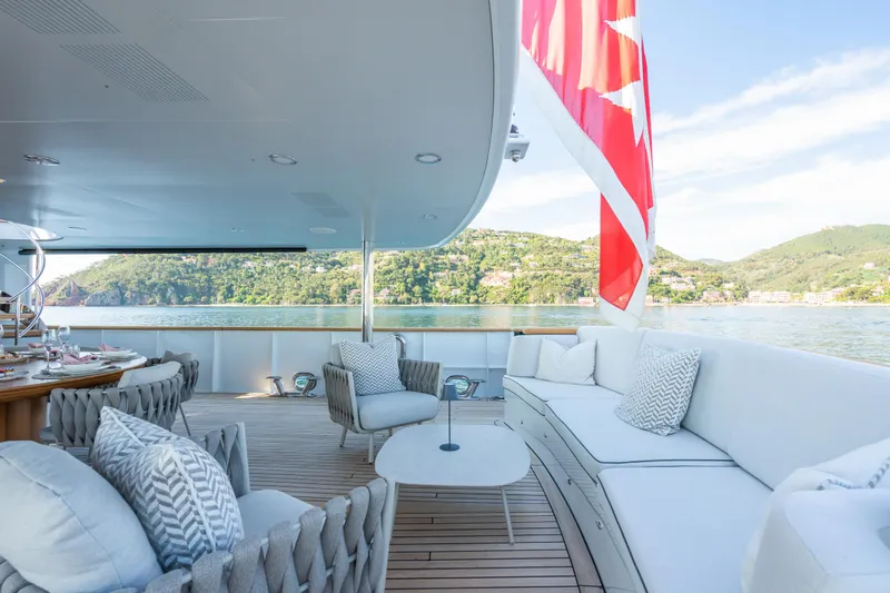 Emerald Yacht Photos Pics Luxurious 1990 Feadship yacht deck with elegant seating and scenic water view.