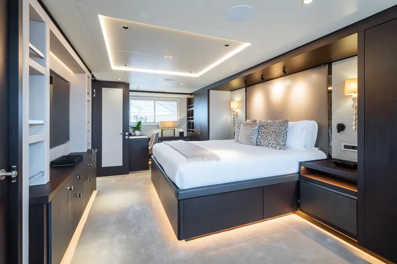 Emerald Yacht Photos Pics Luxurious bedroom interior on a 1990 Feadship yacht, featuring modern design and ambient lighting.