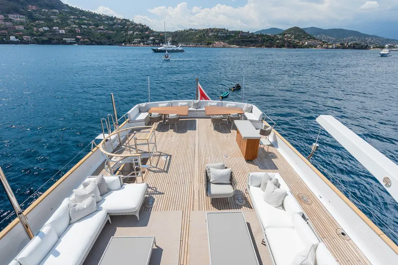 Emerald Yacht Photos Pics Luxurious 1990 Feadship yacht deck with elegant seating, overlooking serene blue waters and scenic coastline.