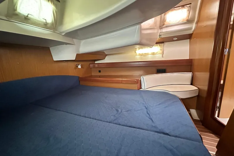  Yacht Photos Pics Interior cabin of 2007 Jeanneau Sun Odyssey 42 DS with blue bedding and wooden accents.