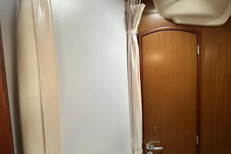  Yacht Photos Pics Interior of 2007 Jeanneau Sun Odyssey 42 DS, featuring wooden door and curtain.