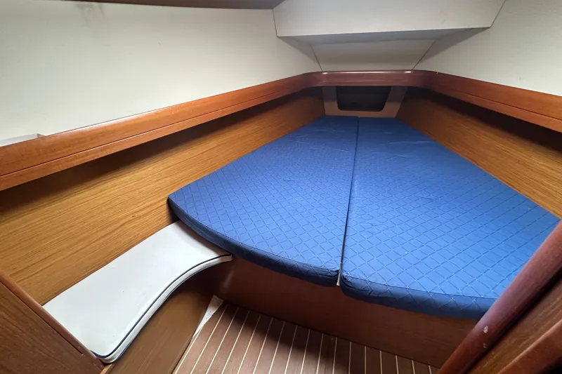  Yacht Photos Pics 2007 Jeanneau Sun Odyssey 42 DS cabin with blue bedding and wooden interior.