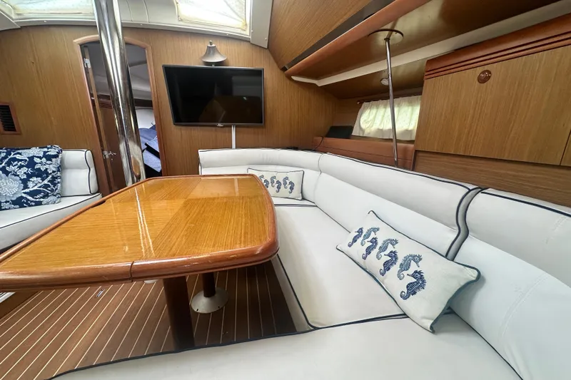  Yacht Photos Pics Interior of 2007 Jeanneau Sun Odyssey 42 DS with elegant seating and wooden table.