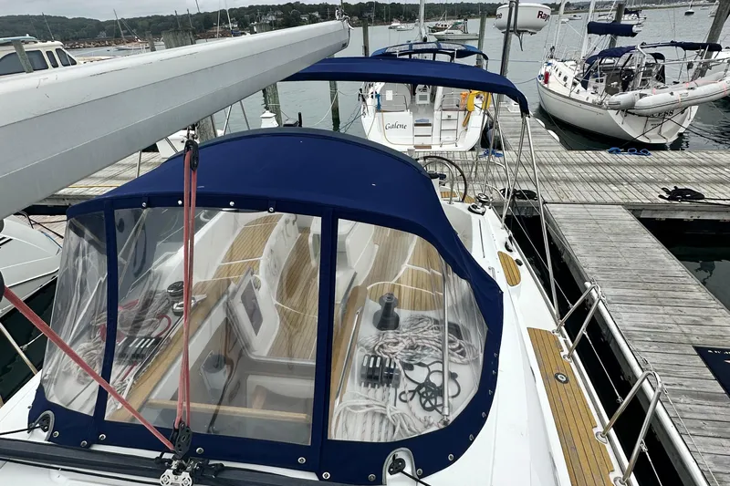  Yacht Photos Pics 2007 Jeanneau Sun Odyssey 42 DS sailboat docked, featuring a blue canopy and wooden deck.
