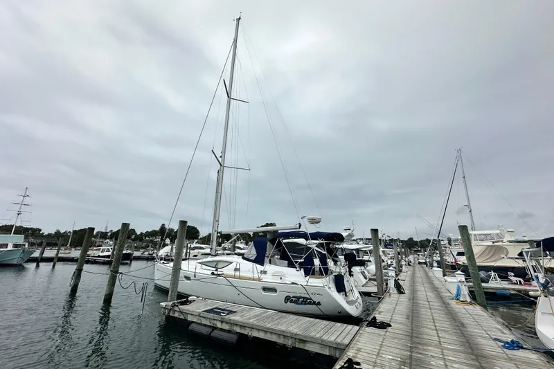  Yacht Photos Pics 2007 Jeanneau Sun Odyssey 42 DS sailboat docked at a marina under cloudy skies.