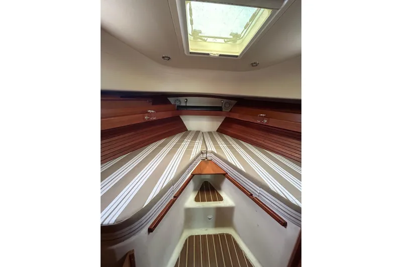 Eagle Yacht Photos Pics 2008 Mainship Pilot 34 cabin interior with striped bedding and wooden accents.