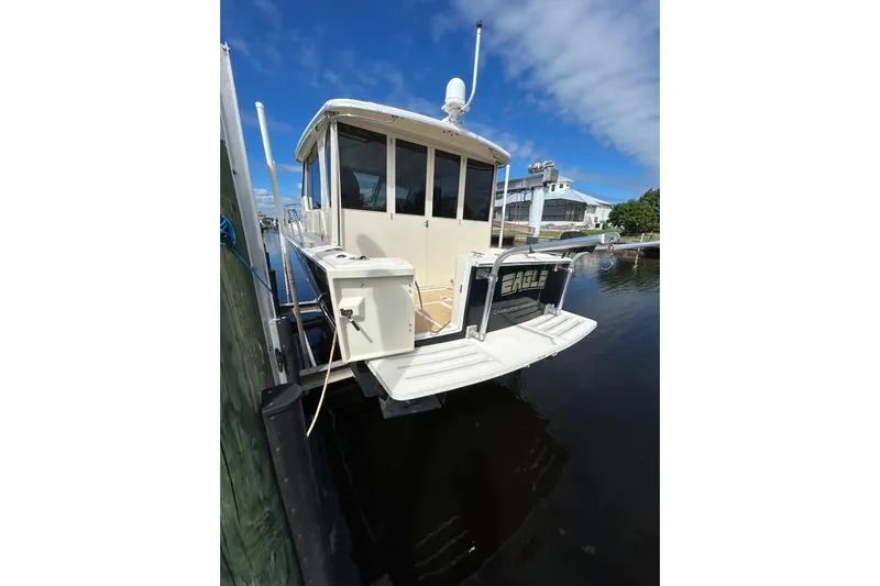 Eagle Yacht Photos Pics 2008 Mainship Pilot 34 docked, showcasing rear deck and cabin under clear blue sky.