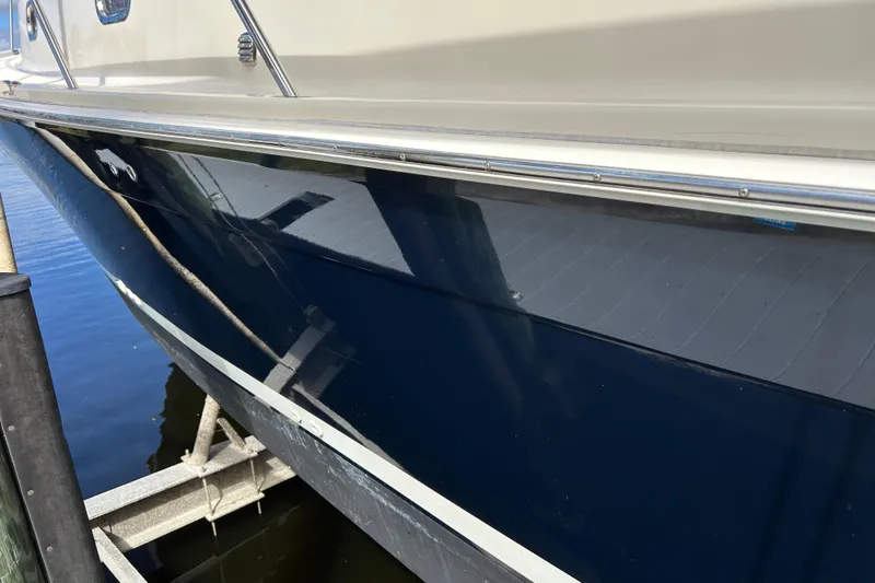 Eagle Yacht Photos Pics 2008 Mainship Pilot 34 boat hull reflecting water, docked at marina.