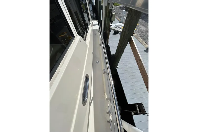 Eagle Yacht Photos Pics 2008 Mainship Pilot 34 boat docked, side view showing deck and railing.