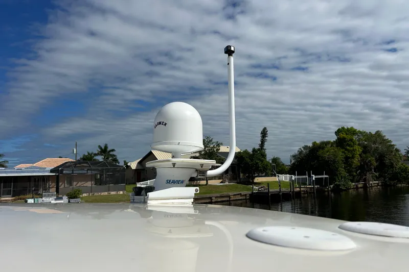 Eagle Yacht Photos Pics 2008 Mainship Pilot 34 with radar equipment, docked near waterfront homes under cloudy sky.