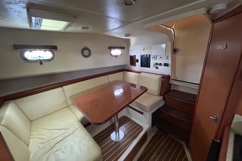 Eagle Yacht Photos Pics 2008 Mainship Pilot 34 interior with cozy seating, wooden table, and nautical decor.