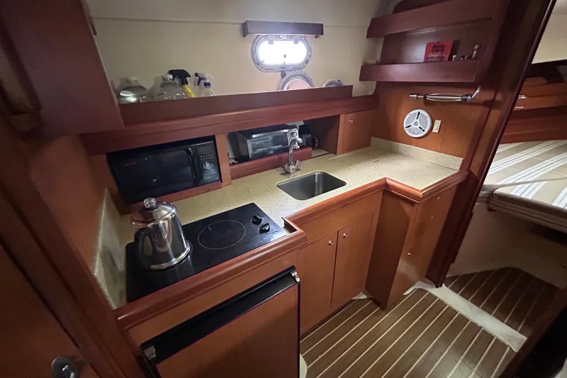 Eagle Yacht Photos Pics 2008 Mainship Pilot 34 galley with stove, sink, and microwave in compact kitchen space.