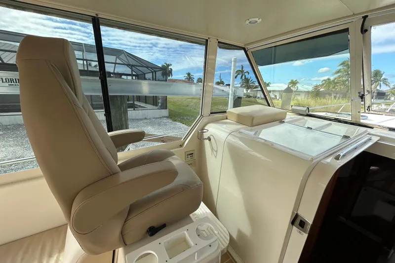Eagle Yacht Photos Pics 2008 Mainship Pilot 34 helm with beige captain's chair and panoramic windows.