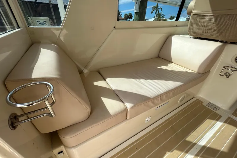 Eagle Yacht Photos Pics 2008 Mainship Pilot 34 interior with beige seating and cup holders, showcasing comfort and style.