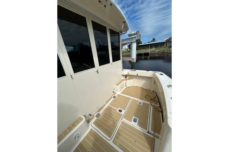 Eagle Yacht Photos Pics 2008 Mainship Pilot 34 boat deck with teak flooring, docked by calm waters.