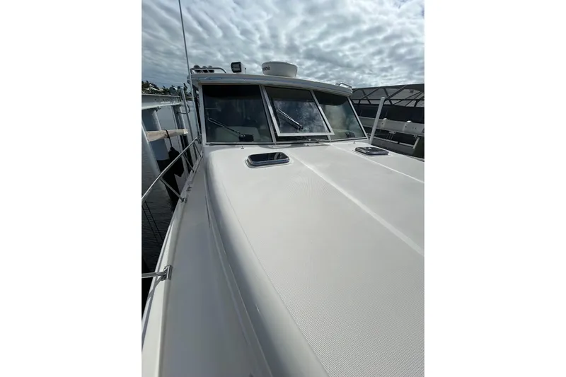 Eagle Yacht Photos Pics 2008 Mainship Pilot 34 boat deck with windows under cloudy sky.