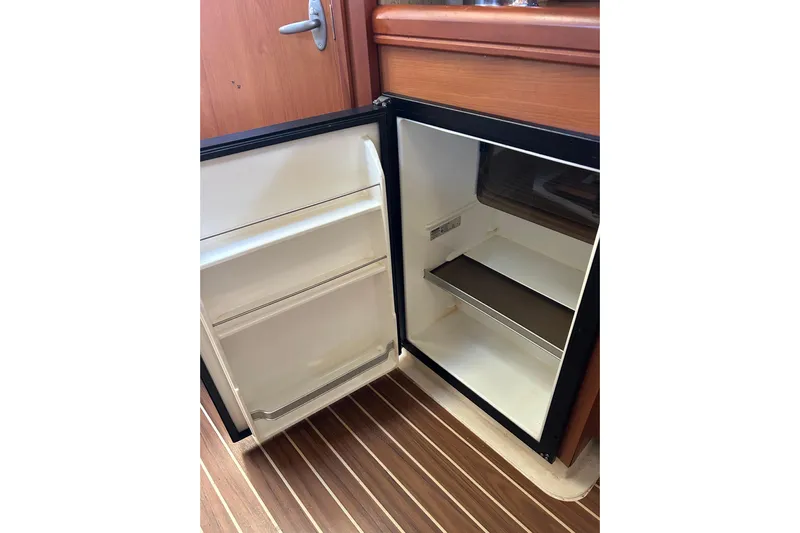 Eagle Yacht Photos Pics Open refrigerator inside 2008 Mainship Pilot 34 boat, wooden floor visible.