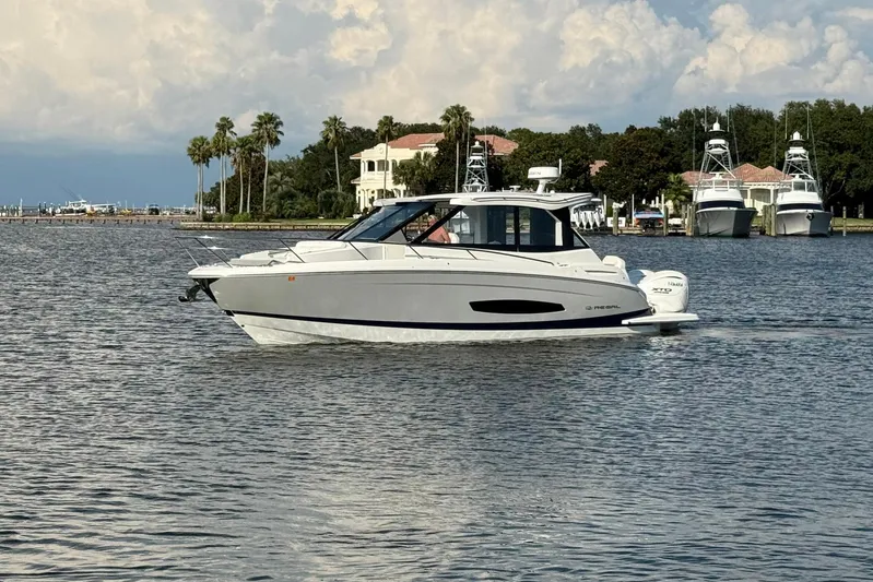 American Rebel Yacht Photos Pics 2025 Regal 36 XO boat cruising on a calm lake with scenic background.