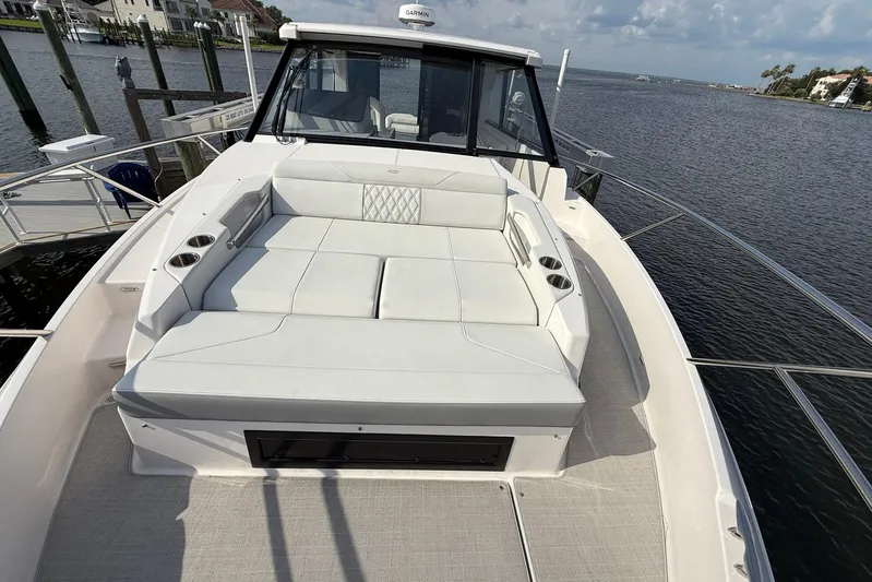 American Rebel Yacht Photos Pics 2025 Regal 36 XO yacht with spacious deck seating, docked by waterfront homes.