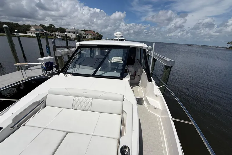 American Rebel Yacht Photos Pics 2025 Regal 36 XO luxury yacht docked, featuring sleek design and spacious deck under cloudy sky.