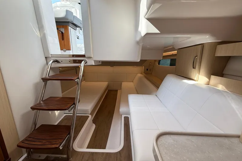 American Rebel Yacht Photos Pics 2025 Regal 36 XO yacht interior with white seating, wooden steps, and modern design.