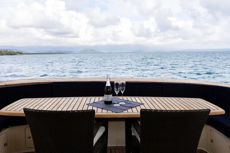 Seabear Yacht Photos Pics Luxury yacht deck with table, chairs, and ocean view; Amanda 72 Explorer, 2006 model.