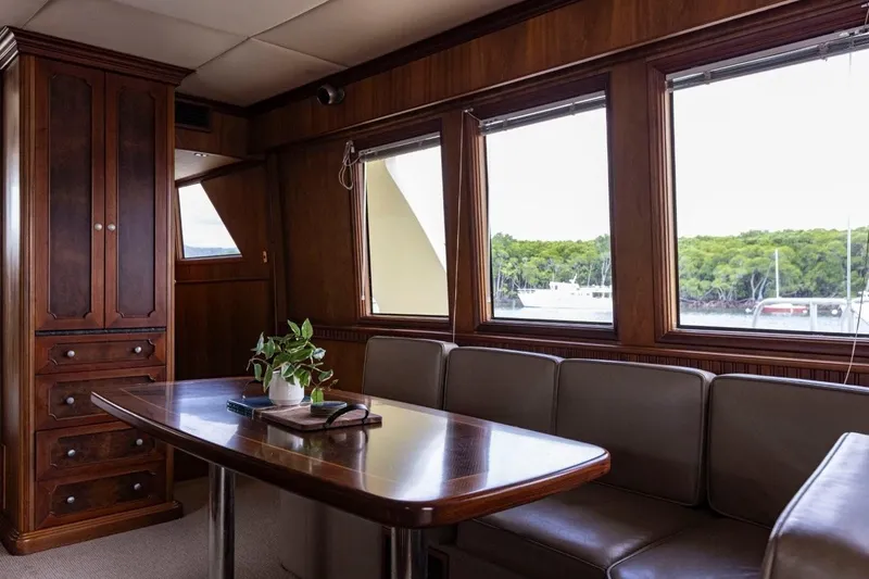 Seabear Yacht Photos Pics Luxurious yacht interior with wooden cabinetry, dining table, and large windows overlooking the water.