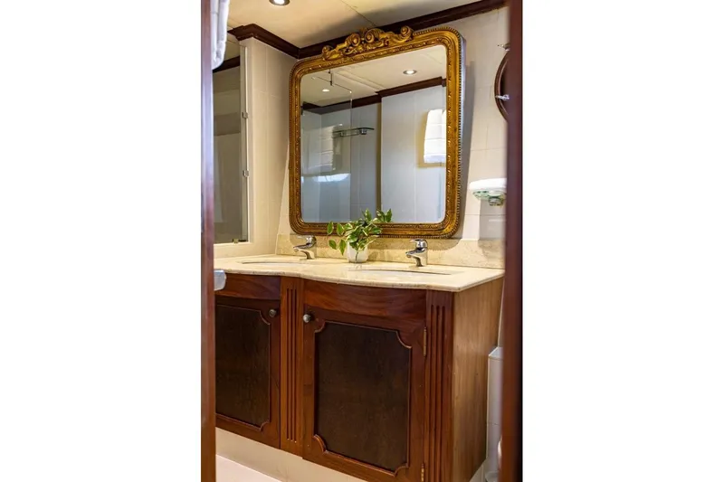 Seabear Yacht Photos Pics Luxurious yacht bathroom with ornate mirror, dual sinks, and elegant wooden cabinetry.