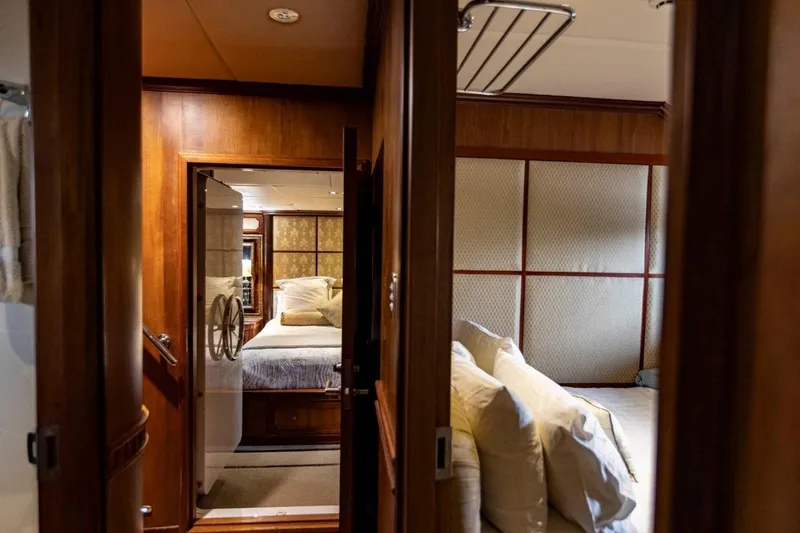 Seabear Yacht Photos Pics Luxurious bedroom interior of 2006 Amanda 72 Explorer yacht with wooden paneling and plush bedding.