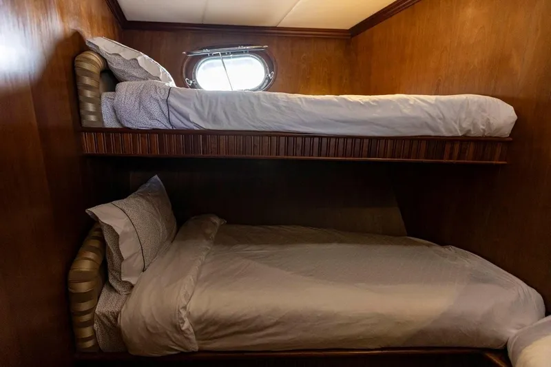 Seabear Yacht Photos Pics Bunk beds in a 2006 Amanda 72 Explorer yacht cabin with wooden walls and a porthole.