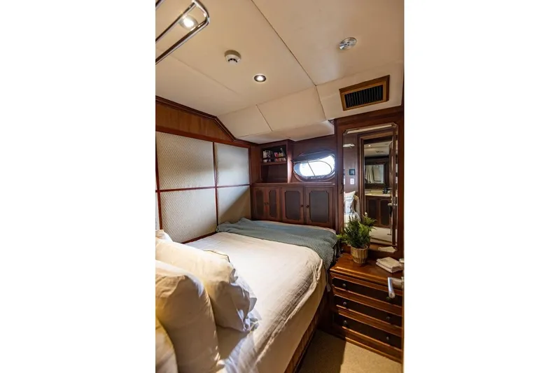 Seabear Yacht Photos Pics Luxurious cabin interior of 2006 Amanda 72 Explorer yacht with cozy bed and wooden decor.