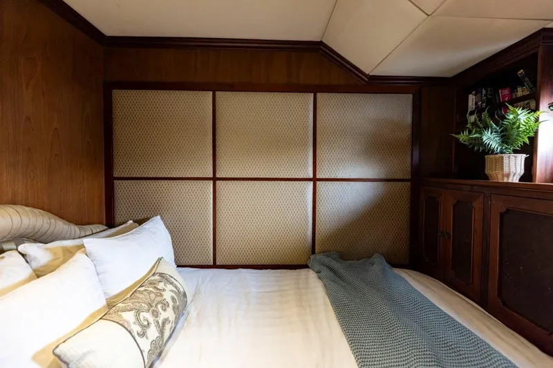 Seabear Yacht Photos Pics Cozy bedroom interior in 2006 Amanda 72 Explorer with wood paneling and decorative pillows.