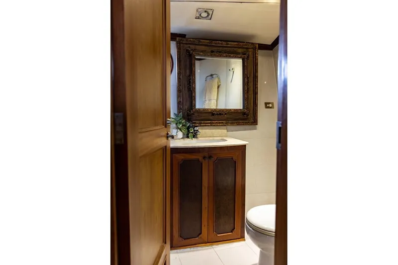 Seabear Yacht Photos Pics Elegant bathroom with wooden cabinetry, ornate mirror, and modern fixtures in Amanda 72 Explorer yacht.