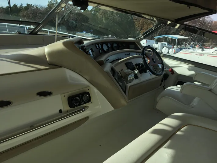  Yacht Photos Pics 1994 Sea Ray 500 Sundancer helm with steering wheel and control panel, docked at marina.