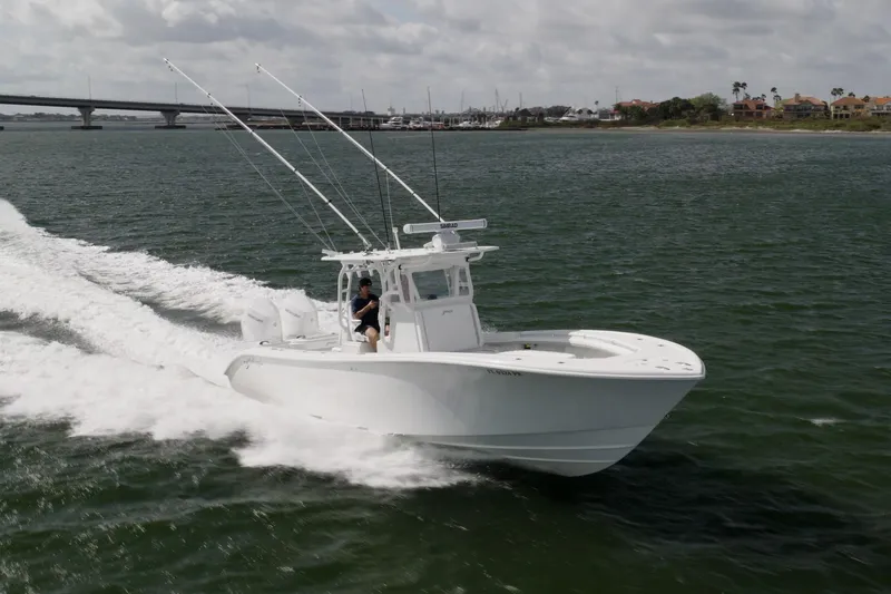 Done Deal Yacht Photos Pics 2014 Yellowfin 32 Offshore boat cruising on open water near a bridge.