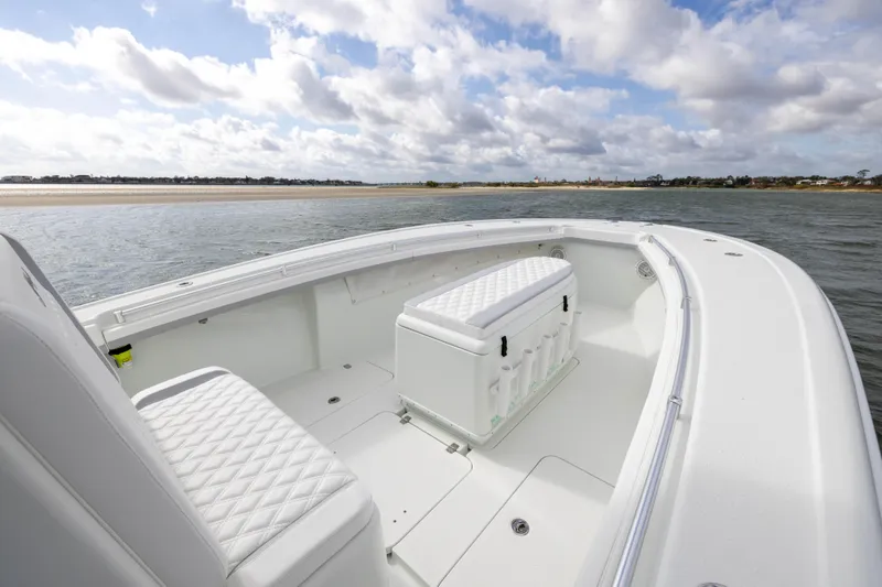 Done Deal Yacht Photos Pics 2014 Yellowfin 32 Offshore boat with white seating, on calm waters under a cloudy sky.