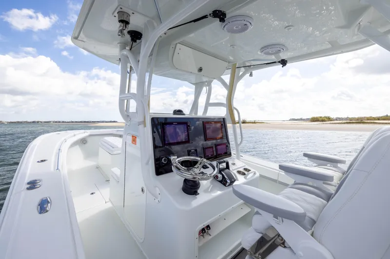 Done Deal Yacht Photos Pics 2014 Yellowfin 32 Offshore boat interior with modern navigation equipment and white seating.