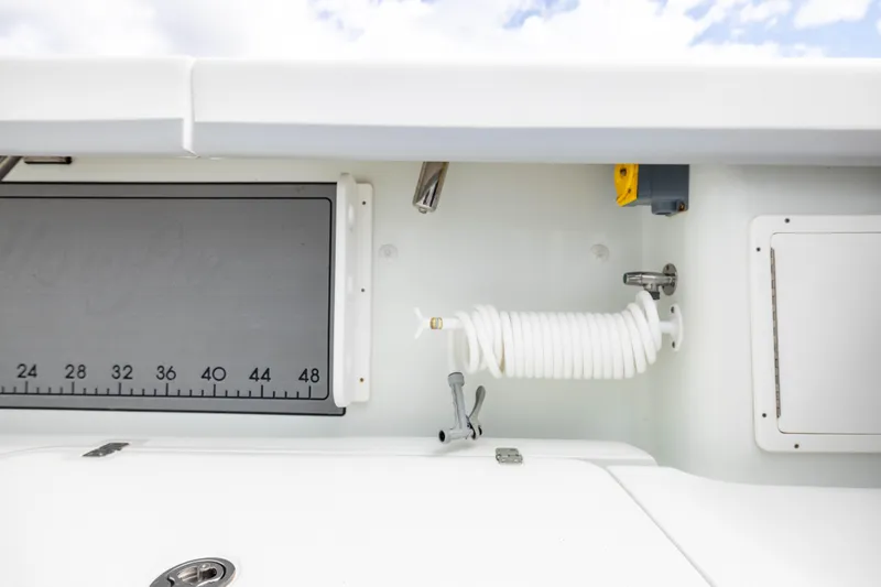 Done Deal Yacht Photos Pics 2014 Yellowfin 32 Offshore boat interior with coiled hose and measurement board.