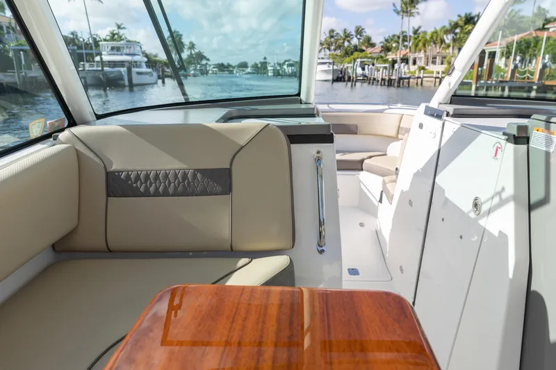 Joysea Yacht Photos Pics 2019 Pursuit DC 325 Dual Console boat interior with luxurious seating and wooden table.