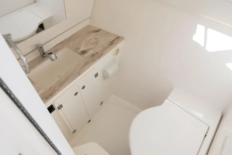 Joysea Yacht Photos Pics 2019 Pursuit DC 325 Dual Console boat bathroom with sink, cabinet, and toilet.
