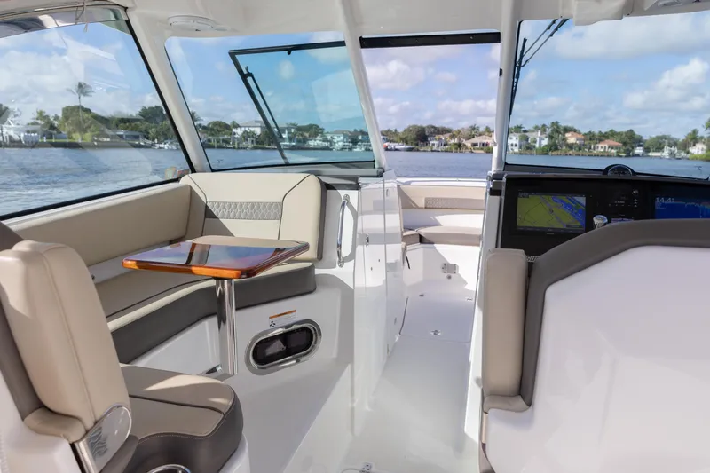 Joysea Yacht Photos Pics 2019 Pursuit DC 325 Dual Console interior with seating, table, and navigation system.