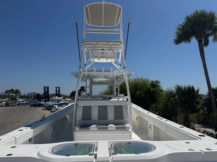  Yacht Photos Pics 2022 Invincible 46 Catamaran with tower, docked under clear blue sky, surrounded by palm trees.